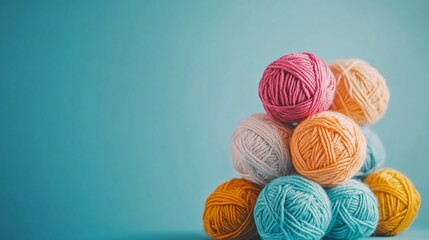 Colorful yarn balls stacked on a blue background.