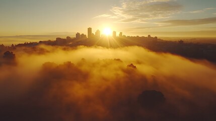 Fototapeta premium Golden sunrise over a city skyline enveloped in misty fog.