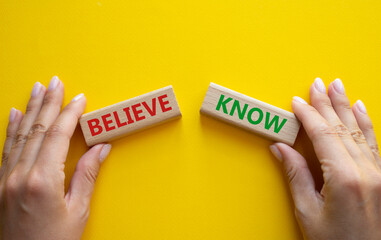 Believe or Know symbol. Concept word Believe or Know on wooden blocks. Businessman hand. Beautiful yellow background. Business and Believe or Know concept. Copy space