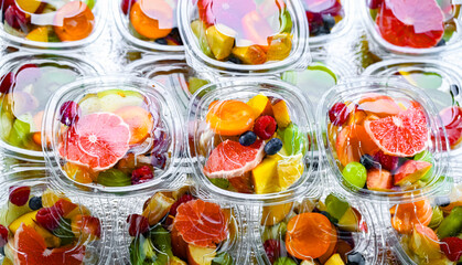 Boxes with pre-packaged fruit salads in a commercial fridge