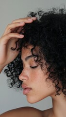 A close-up of the woman's hand running her fingers through her curly hair, using an organic shampoo product for thickening hair. generative ai