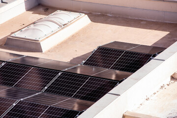 Rows of solar panels installed on a flat rooftop, capturing sunlight for renewable energy in an urban residential setting.