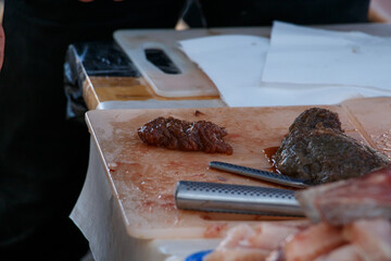 Fish roe on the cutting board, with a knife and fish pieces beside it.