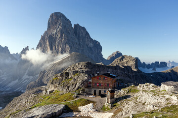 Mountain panorama, morning light on peaks of the Sesto Dolomites with a hut, South Tyrol, Alps,...