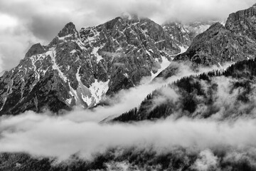 Snow covered peaks of the Sesto Dolomites in clouds, mountains of the Alps, black and white photo, South Tyrol, Italy, Europe