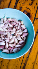 Garlic in blue bowl on wooden table