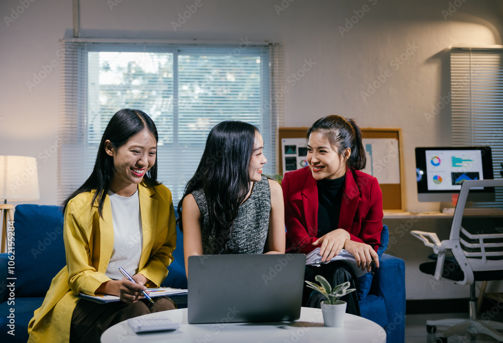 Poster three young businesswomen are smiling and collaborating on a project, using a laptop and documents i