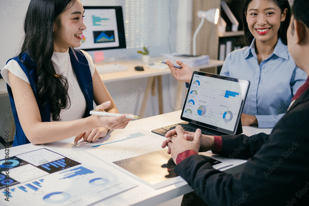 Poster asian businesswomen presenting financial charts and graphs on a tablet to a businessman during a pro