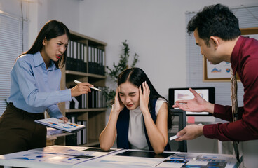 Business colleagues arguing and blaming stressed businesswoman during a late night meeting in...