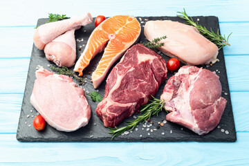 Mix of raw meat and fish . Salmon , beef , pork , chicken staek . Top view