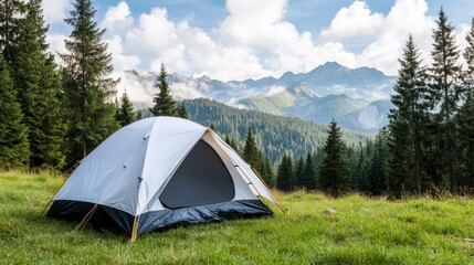 A cozy tent is set up on a lush green meadow, surrounded by tall trees and majestic mountains. The clear sky enhances the tranquil camping atmosphere in this natural setting