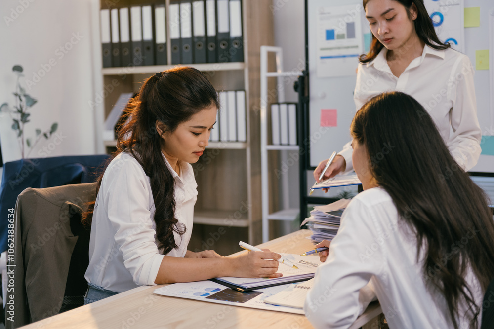 Aufkleber three asian businesswomen are discussing and analyzing financial charts and graphs using documents a