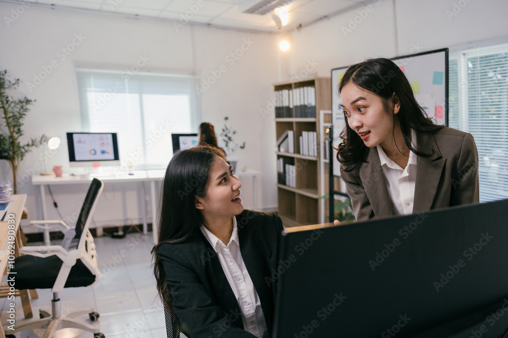 Aufkleber two asian businesswomen are discussing a project in front of a computer, sharing ideas and collabora