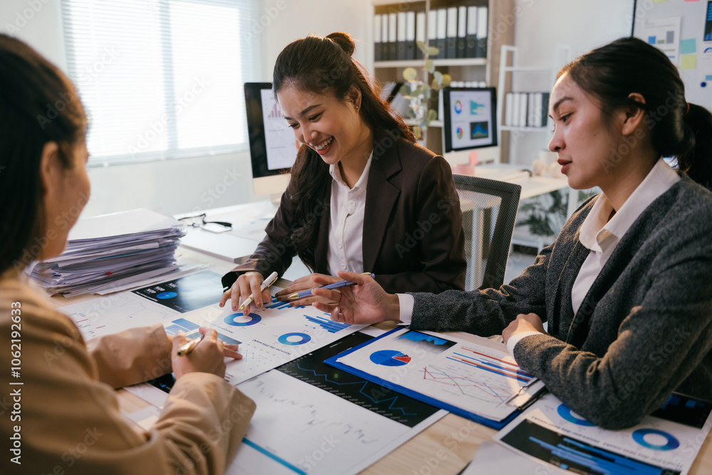 Poster three asian businesswomen are analyzing financial charts and data in a brightly lit office, collabor