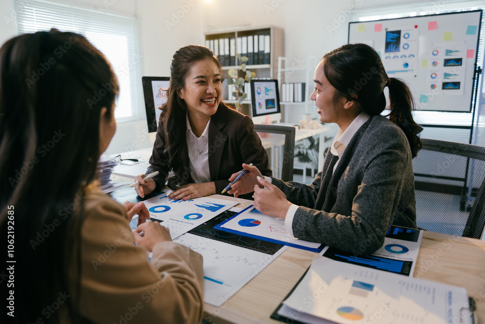 Poster asian businesswomen are discussing charts and pie graphs during a meeting in a modern office, collab