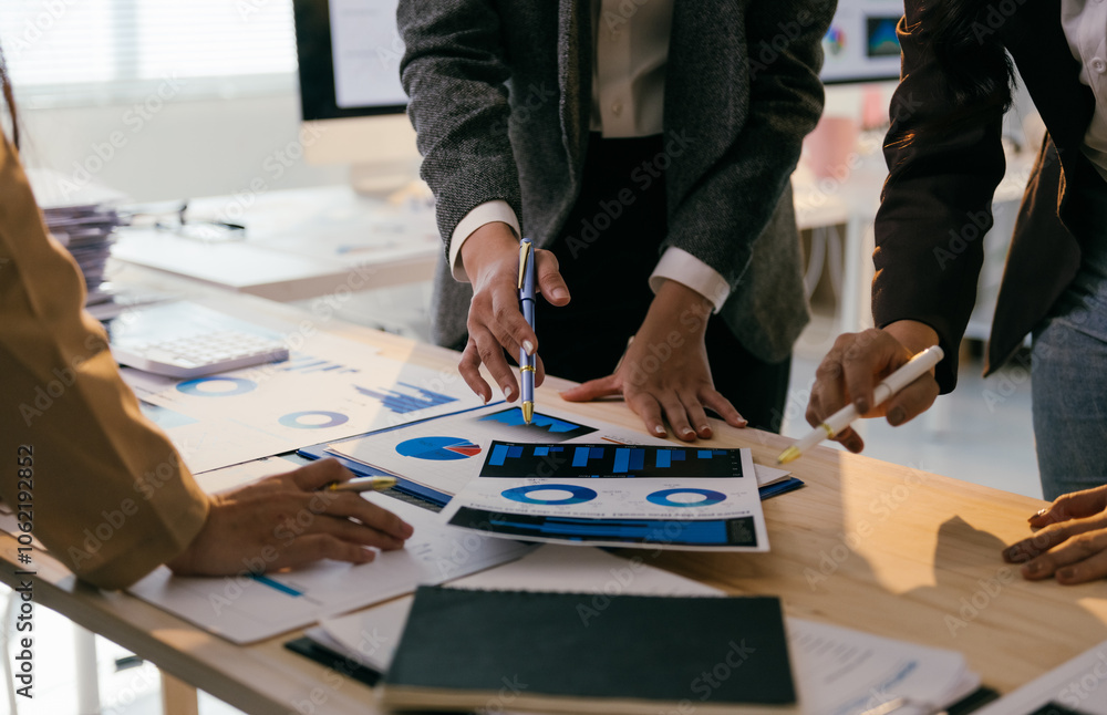Poster Business team analyzing financial charts and statistics, pointing at graphs and discussing data during a collaborative meeting in a modern office