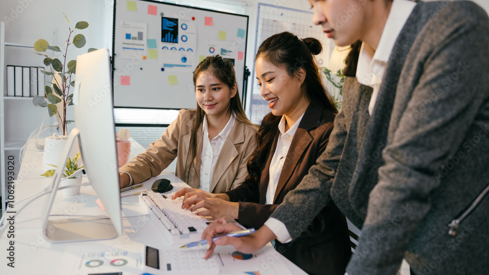 Aufkleber Three asian businesswomen are collaborating on a project, analyzing data on a computer and reviewing financial documents in a modern office setting