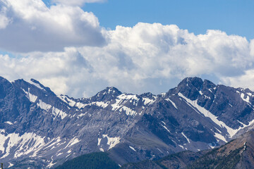Obraz premium Majestic Snow-Capped Mountains Under Cloudy Blue Sky