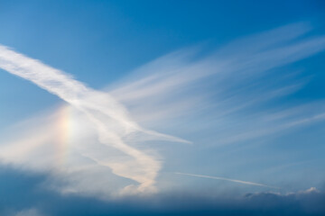 Sky with cirrus, stratus clouds and halo from the sun, rainbow