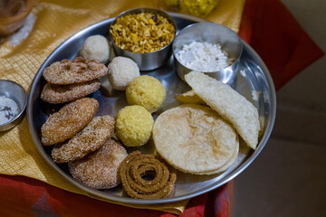 A traditional Indian festive platter featuring assorted sweets like laddus, puffed rice (murmura), chivda (spicy snack mix) , chakli, ladoo perfect for diwali celebration 