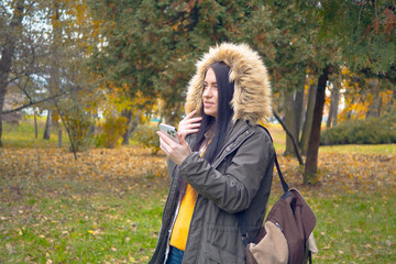 A young, beautiful girl travels in nature, admires the beauty of the autumn forest with admiration,...