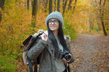 A young, beautiful girl travels in nature, admires the beauty of the autumn forest with admiration,...