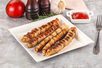 Grilled meat sausages wrapped bacon