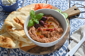 Sun-dried tomato kalamata olive hummus with naan, carrots and cucumbers Mediterranean tiles, homemade recipe