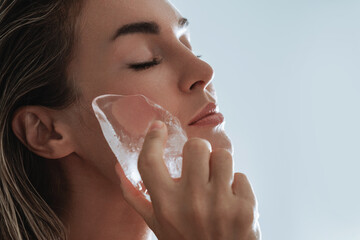 Beautiful Young Woman Applying Ice Therapy to Her Face