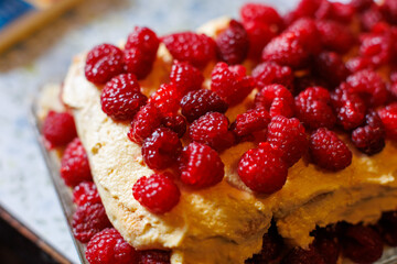 A fresh raspberry cream cake topped with vibrant berries