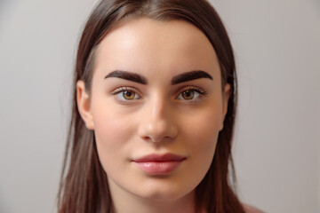 Beautician showing perfect eyebrows after treatment in beauty salon