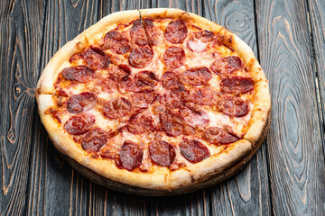 Pizza pepperoni fast food . Top view on rustic background