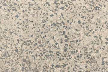 Concrete texture. Pebbles of different colors and signs of aging are visible.