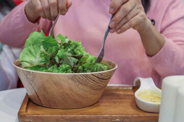 Asian women enjoy Fresh Tuna Salad in wooden bowl for good healthy cooking cuisine