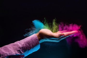 Two hands showing a sale advertisement copy space and black background with burst of colors with...