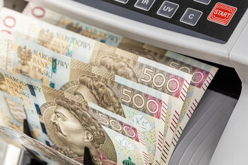 Poland money. Polish banknotes of 500 zlotys in a cash counting machine. Business and finance concept, exchange rate, financial calculations, close up