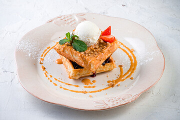 Belgian waffles with ice cream on a light background