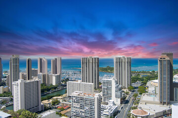 aerial shot of the Ala Wai Canal with skyscrapers, hotels and condos, lush green trees and cars...