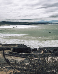 Atlantic Ocean waves whipping white foam against the rocky shore, Ericeira, Portugal.
