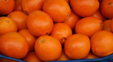 Fresh oranges texture. Natural orange fruits as background.Top view of Spanish oranges in a box.