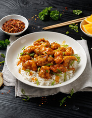 Chinese orange chicken with rice and green onion garnish