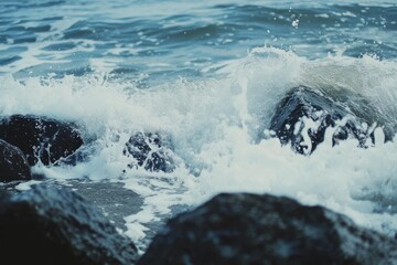 A panoramic view of waves crashing on rocky coastline, showcasing the power and beauty of nature.  The image captures the force of the ocean as waves break upon the rocks, creating a dramatic and capt