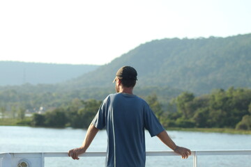 homem em sacada de barco no rio amazonas, pará 