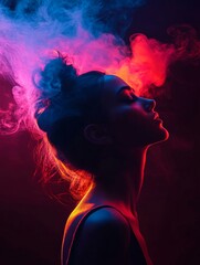 A woman's silhouette is highlighted by colorful smoke in this artistic and captivating photograph, representing beauty, mystery, freedom, sensuality, and imagination.