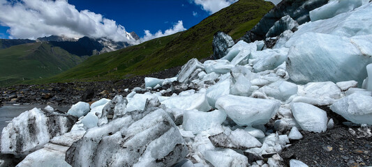 Melting of a mountain glacier and large blocks of snow on the Alibek glacier in Dombai, in the...