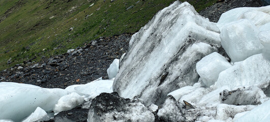 Melting of a mountain glacier and large blocks of snow on the Alibek glacier in Dombai, in the...