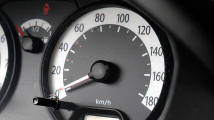 Closeup of car speedometer dashboard with speed dial in kilometers per hour and fuel gauge,...