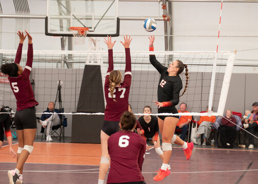 Volleyball player dinking the ball during college sixes match - Powered by Adobe