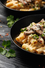 Philly cheese steak pasta in black bowl