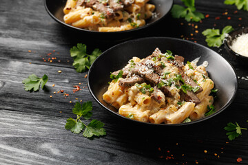 Philly cheese steak pasta in black bowl